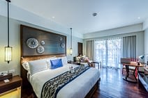 a spacious bedroom with a girl on the couch